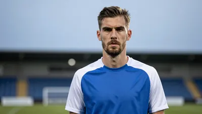 A determined, rugged Sandefjord midfielder, aged 28, with a strong build, wears a plain blue and white training top...